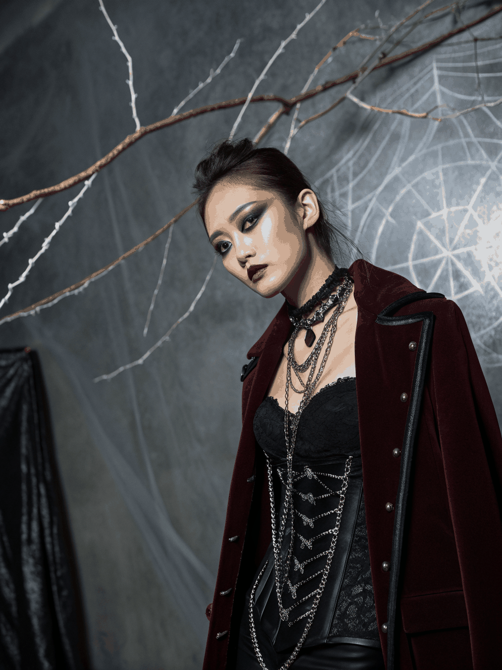Model wearing a black and burgundy ARVÉ gothic streetwear set with sheer lace sleeves and a glowing chrome heart chest graphic