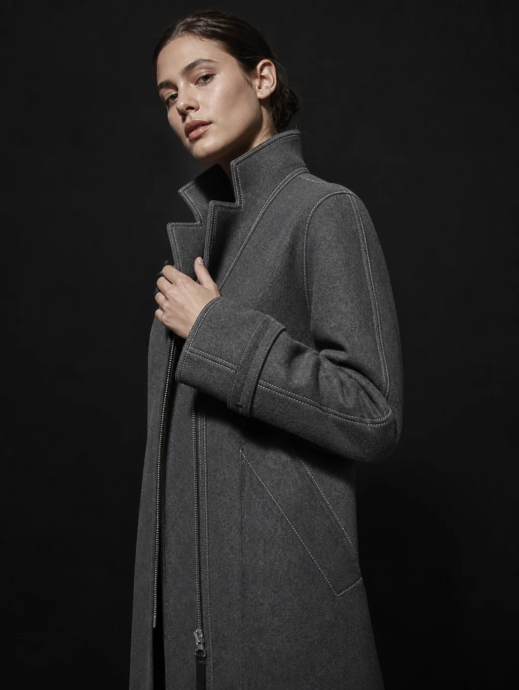 Editorial model wearing ARVE tailored architectural dark overcoat in minimalist studio
