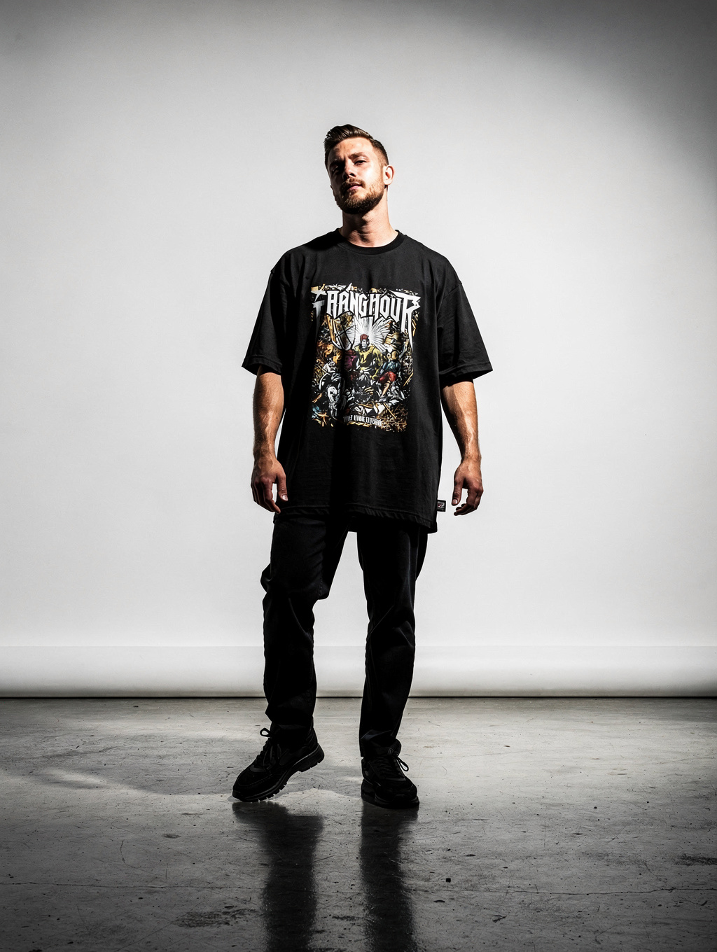 Model wearing ILLEGAL SOUNDS dark graphic heavy print t-shirt in ambient lighting